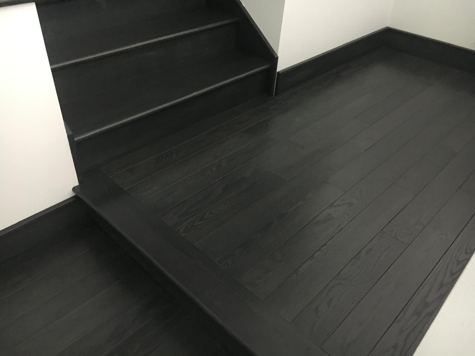 Ebonized oak floor running into matching stair treads — white oak, custom commission