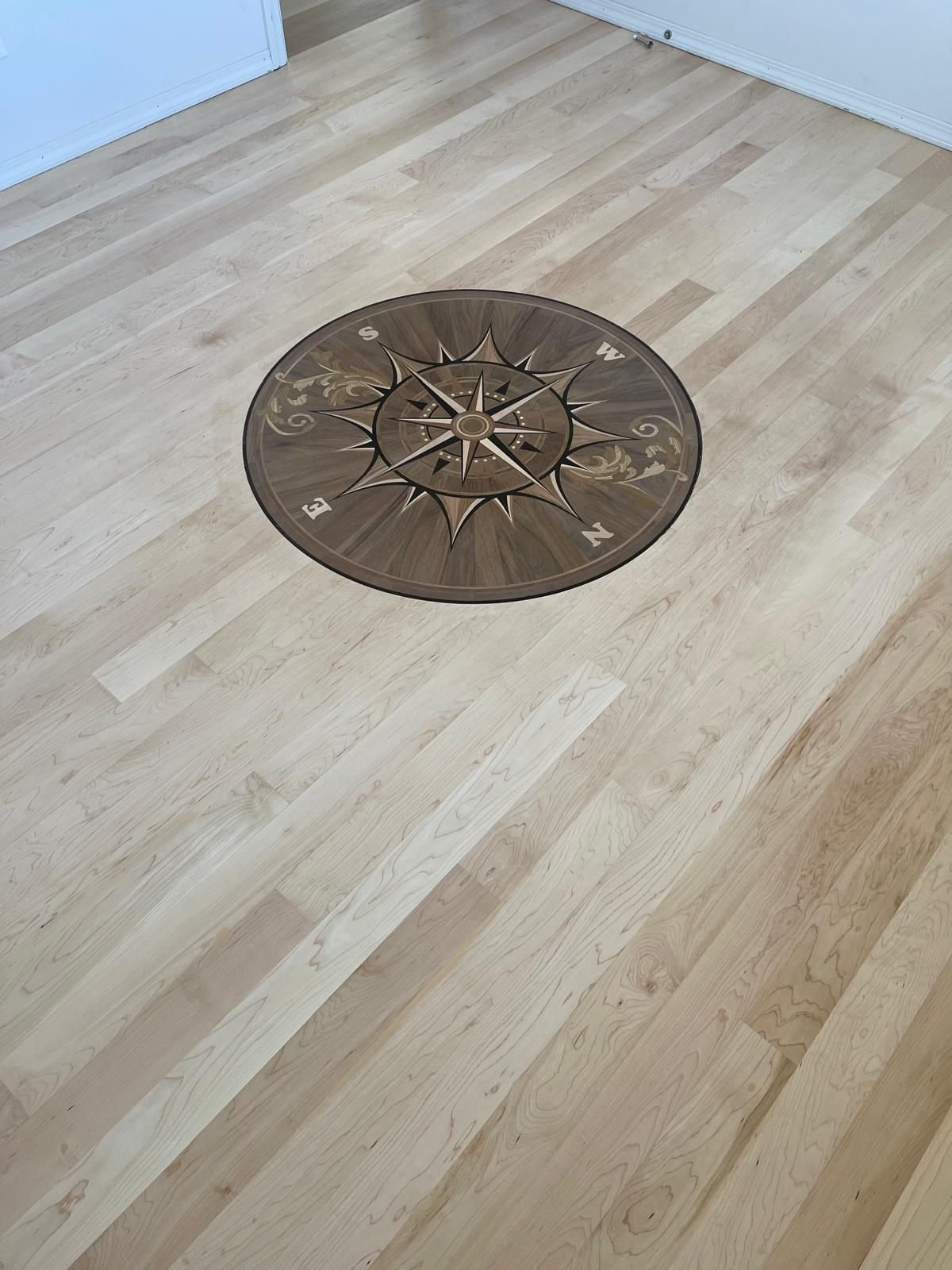 Rose compass medallion set flush into a hard maple field — walnut and maple, custom commission