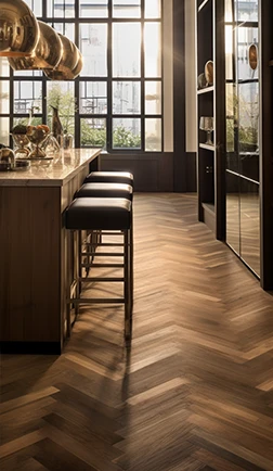 Warm herringbone wood flooring beside a kitchen island and bar stools
