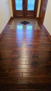 Entry hall with dark hand-scraped hardwood and a tile inlay medallion at the door