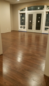 Open living space with rich dark-stained hardwood flooring by AG Floor Covering