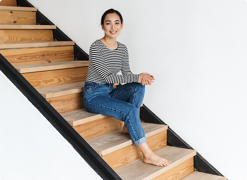 Smiling young woman sitting on a wooden staircase
